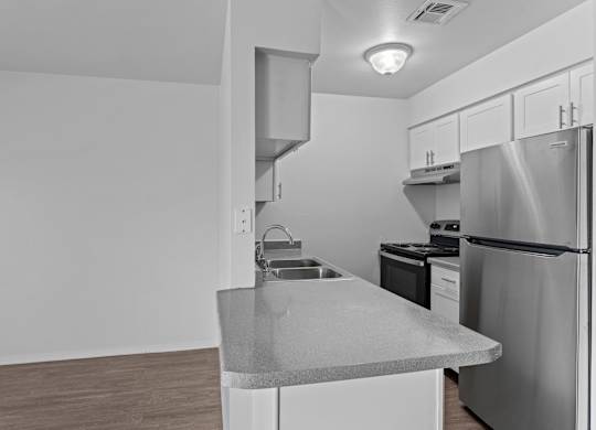 A kitchen with a stainless steel refrigerator and a countertop.