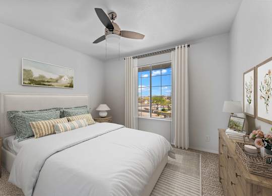 A bedroom with a large bed and a ceiling fan.