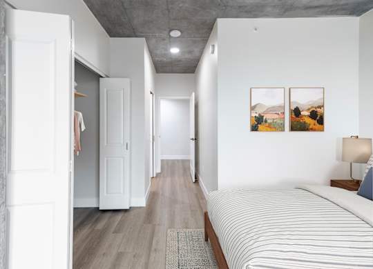A long hallway with a bed on the right side.