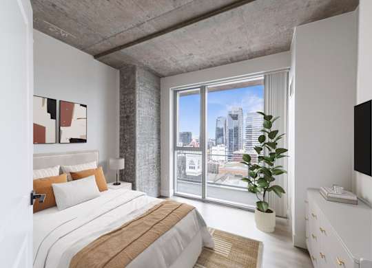 A bedroom with a large bed and a view of the city.