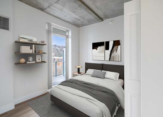 A bedroom with a bed, pillows, and a window.