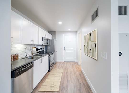 A modern kitchen with stainless steel appliances and white cabinets.