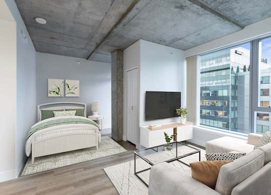 A bedroom with a bed, a couch, and a television.