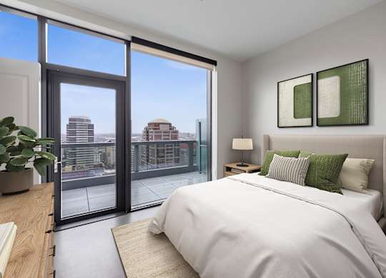 A bedroom with a large bed and a view of the city.