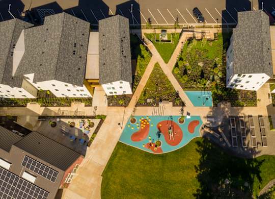 A playground with a slide and a green lawn.