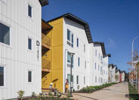A white building with a yellow section in the middle of it.