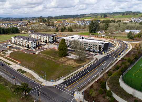 A road with a roundabout and a building in the distance.