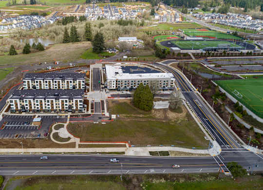 An aerial view of a large building with a parking lot in front of it.