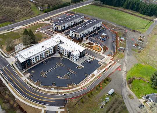 A large building complex with a parking lot in front.