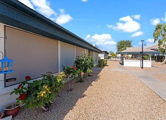 A gravel path leads to a building with a covered patio.