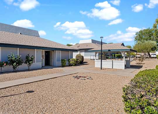 A building with a gravel driveway in front.