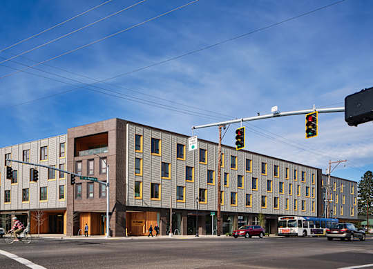 A street view of a modern building with a clear blue sky.