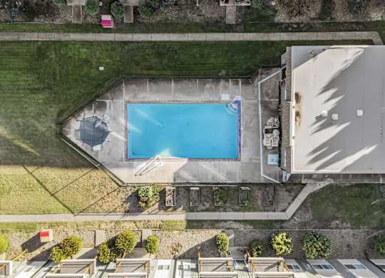 an aerial view of a swimming pool in the backyard of a house