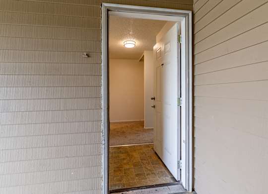 A white door is open to a hallway.