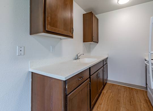 A kitchen with wooden cabinets and a white countertop.