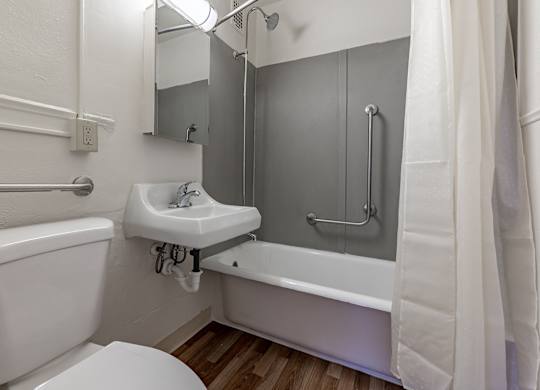 A white bathroom with a toilet, sink, and bathtub.