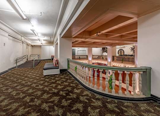 A long hallway with a bench and a railing.