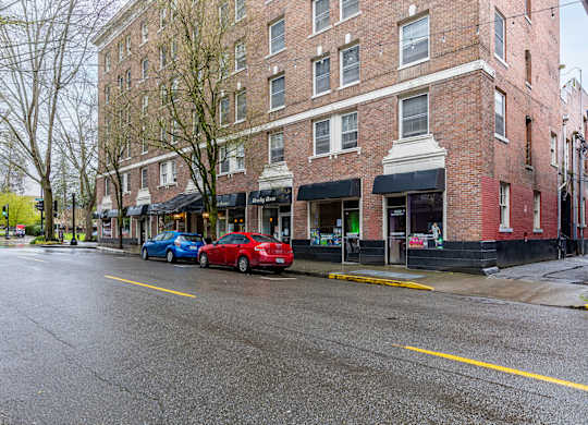 A red car is parked on the side of the street.