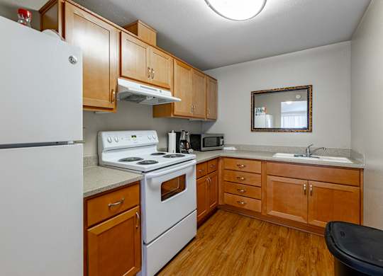 A kitchen with wooden cabinets and a white refrigerator.