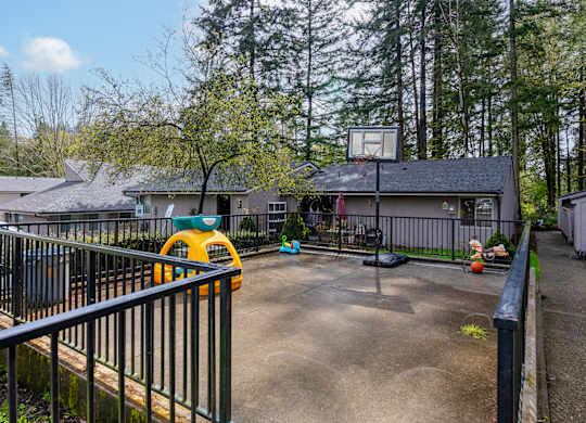 A yellow toy car is parked on a concrete driveway.