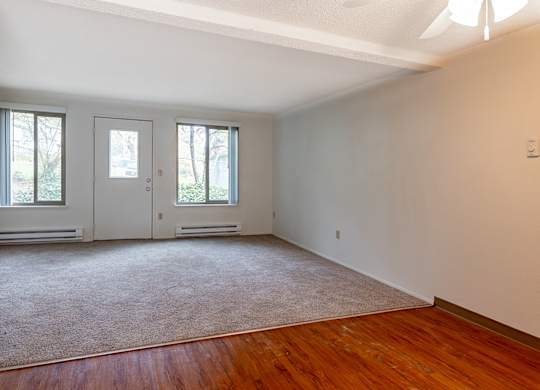 A room with a carpeted floor and a white wall.