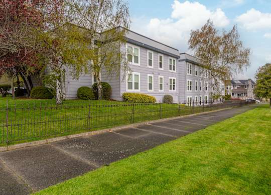 A long building with a fence in front of it.
