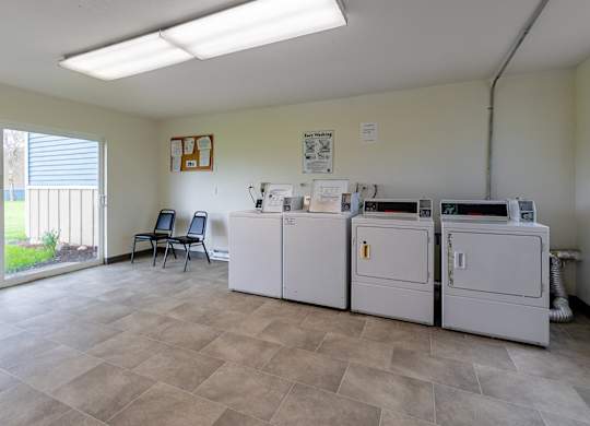A room with a white fridge, a white washing machine, a white dishwasher, and a white dryer.