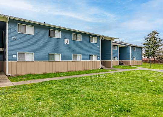 Apartment building with blue siding and white windows.