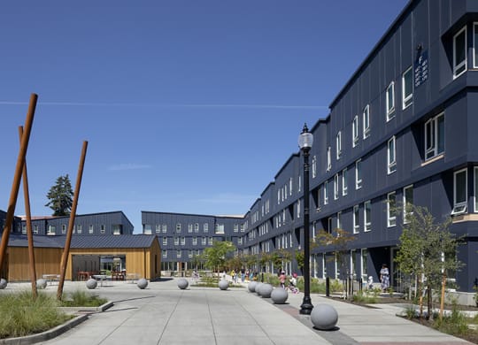 a courtyard in front of a building with a blue sky in the background