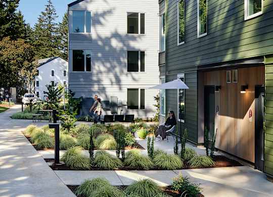 A modern house with a green exterior and a white roof.