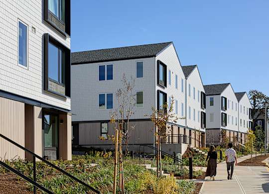 A row of modern houses with a person walking in front of them.