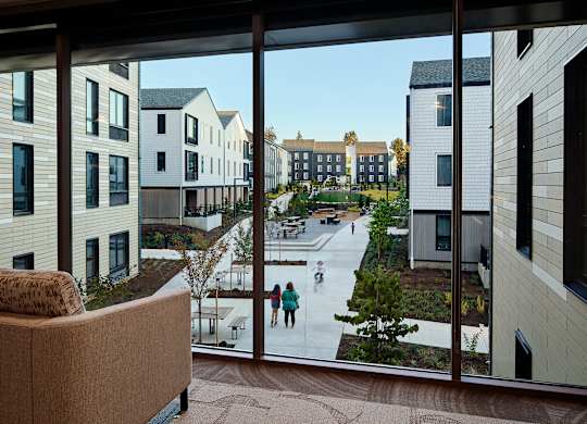 A view from a window of a courtyard with people skating.