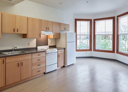 A kitchen with wooden cabinets and a white refrigerator.