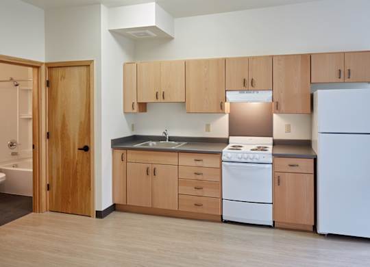 A kitchen with wooden cabinets and white appliances.