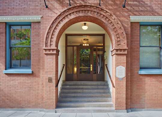 A red brick building with a white sign on the wall.