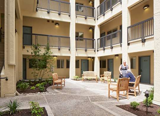 A courtyard with a woman sitting on a chair.