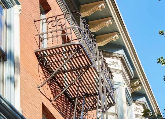 A fire escape on a red brick building.