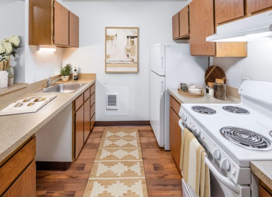 a kitchen with wooden cabinets and a white stove top oven
