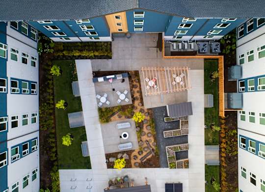 A courtyard surrounded by buildings with a table and chairs.