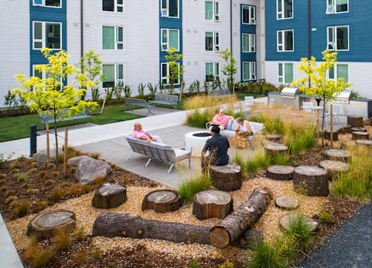 A small garden with a bench and a tree.