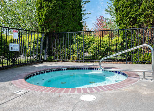 A small round pool with a metal fence around it.