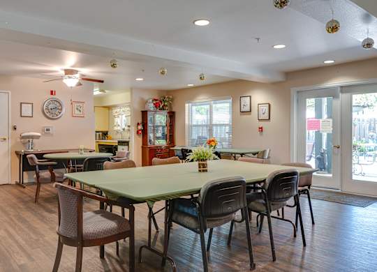 A dining room with a green table and chairs.