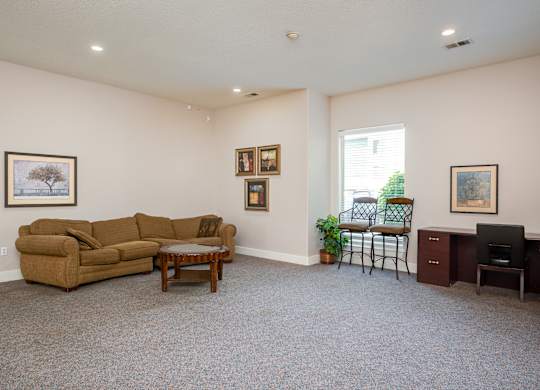 A living room with a couch, chair, and pictures on the wall.
