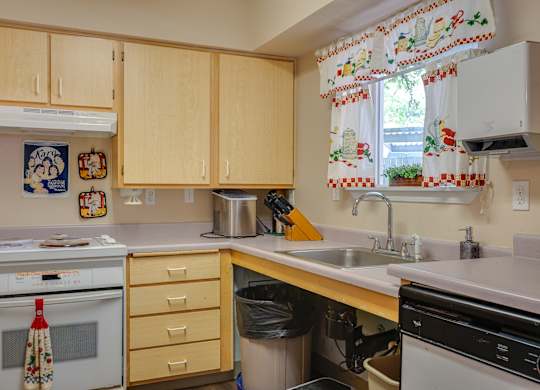 A kitchen with wooden cabinets and a white oven.