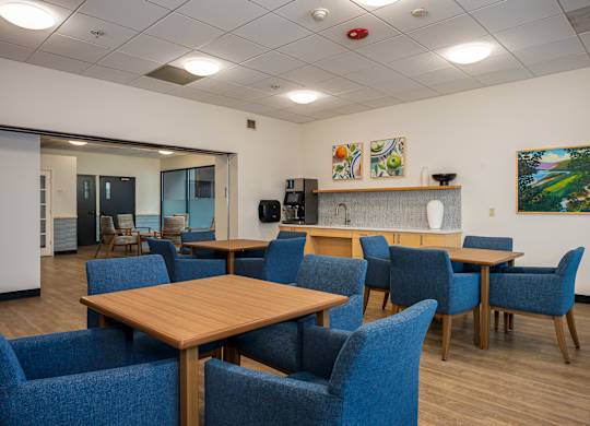 A conference room with blue chairs and a wooden table.