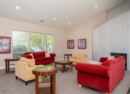 A living room with a red couch and a fireplace.