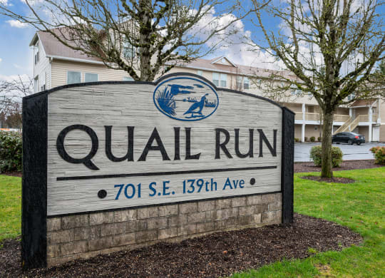 a sign that says quail run in front of a building
