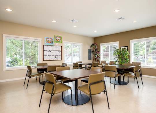 A room with a table and chairs and a calendar on the wall.