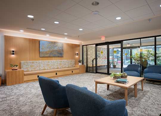 A room with blue chairs and a wooden table.