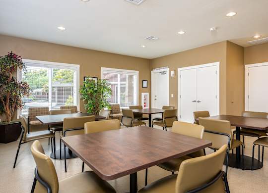 A large brown table surrounded by chairs in a room with brown walls.